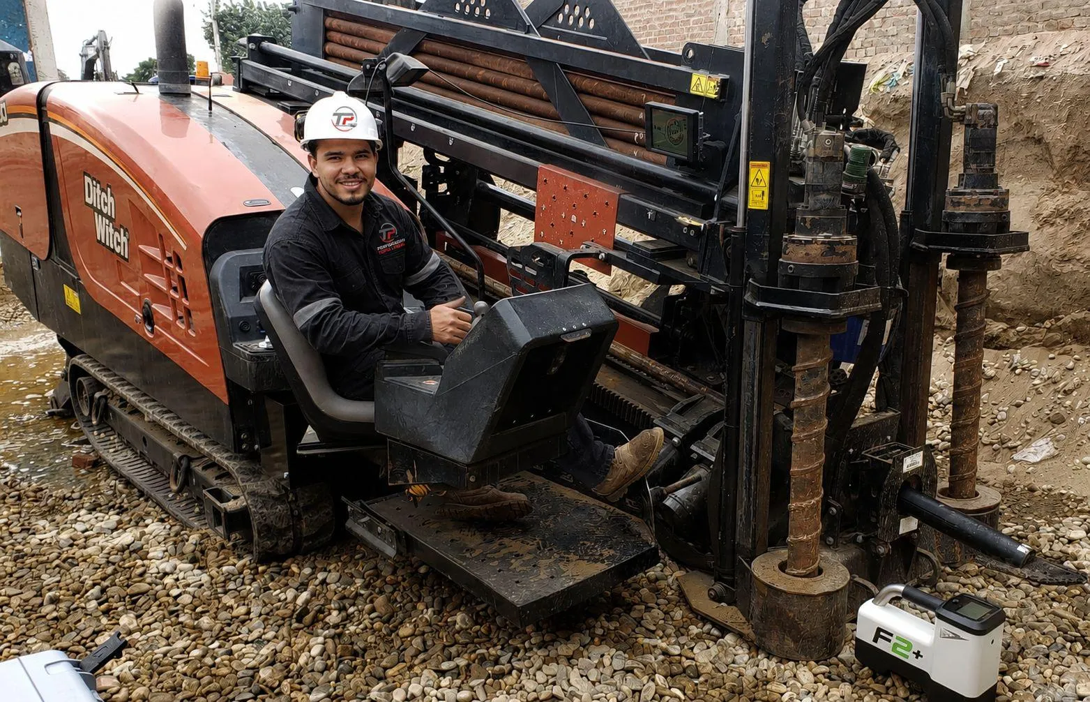 Operario de Perforación Topo Lineal sonriendo a los mandos de la máquina perforadora HDD Ditch Witch con equipo de guiado